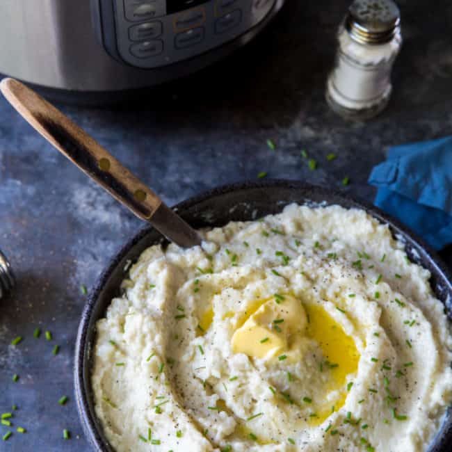 cauliflower mashed potatoes dish served and topped with fresh herbs