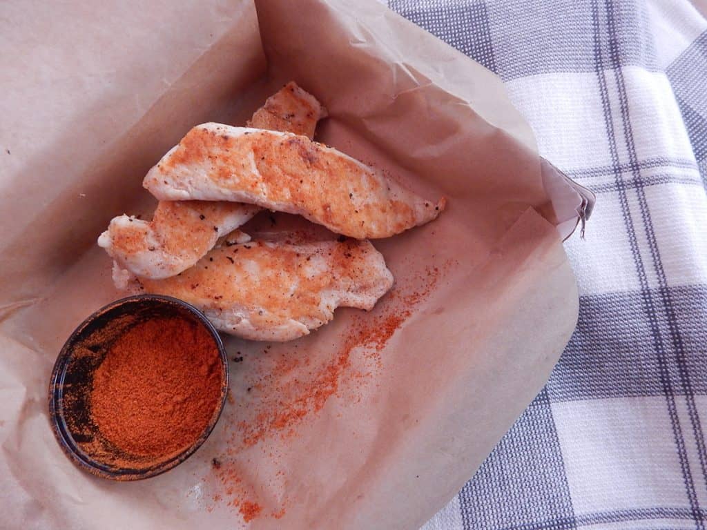 Naked Tenders stacked next to chipotle seasoning