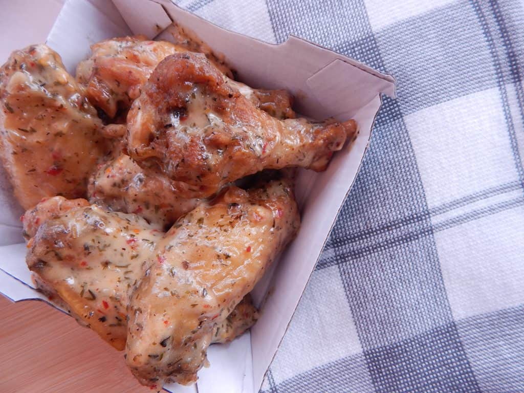 Parmesan garlic wings stacked inside a to- go box
