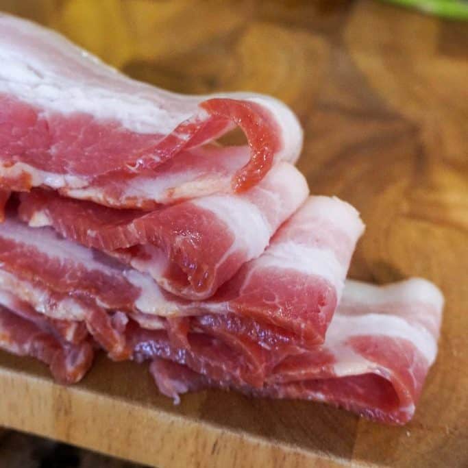 Raw bacon on a cutting board