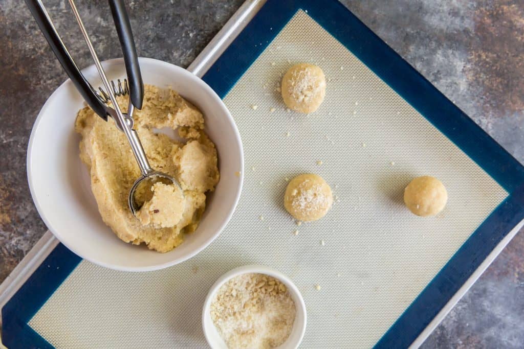 Using a cookie scoop to make even balls on a silpat mat.