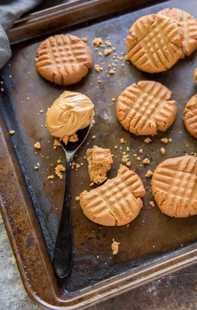 Keto peanut butter cookies next to a heaping spoonful of peanut butter
