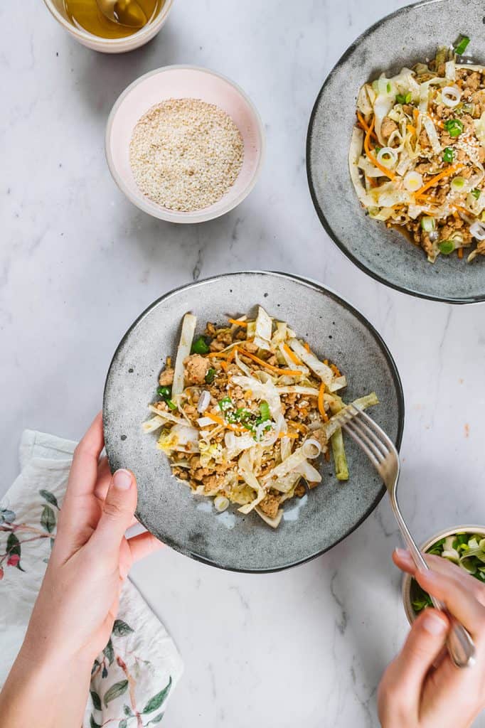 Eating the finished egg roll in a bowl with a silver fork