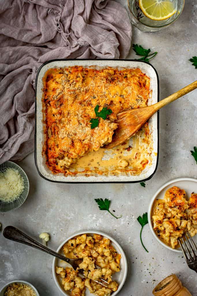 Mac and cheese on two plates with forks next to the baking dish