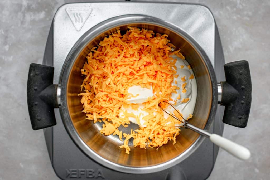 Cauliflower Mac and Cheese A saucepot filled with cheddar cheese to be cooked down into a cheese sauce