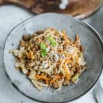 egg roll in a bowl served on a plate with cutting board in the background