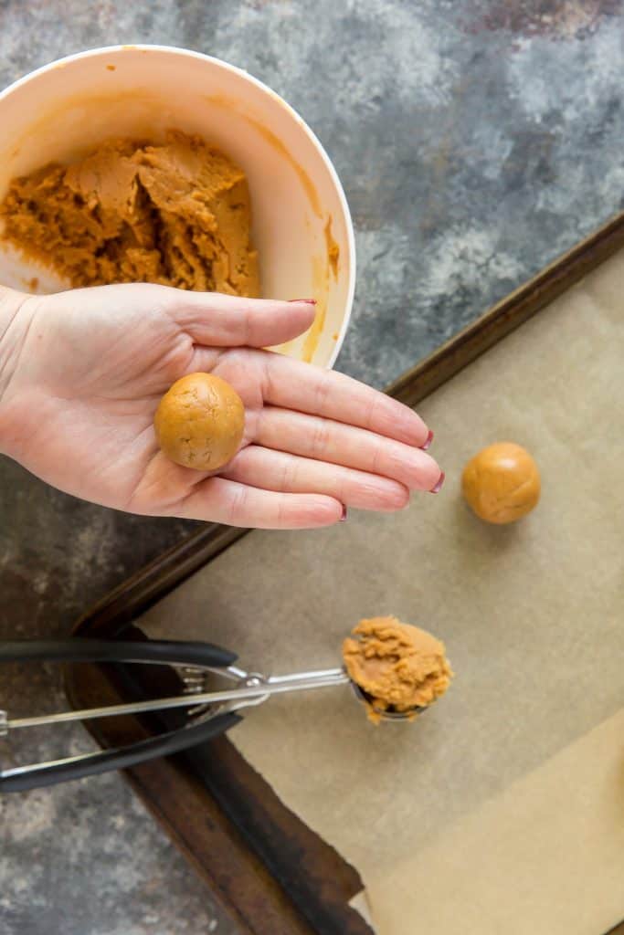 Keto Peanut Butter Cookies Rolling cookie dough with a cookie scoop to bake