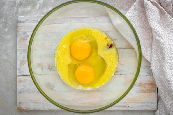 Eggs, butter, and vanilla extract in a glass bowl. 