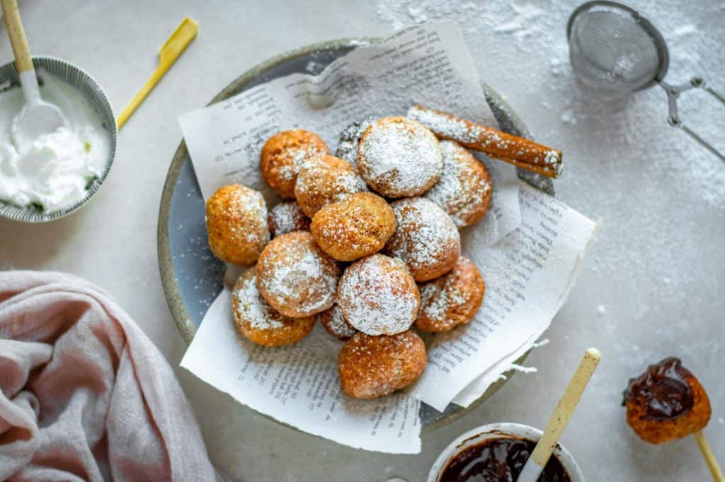 Keto donuts on top of newspaper sprinkled with powdered sweetener.