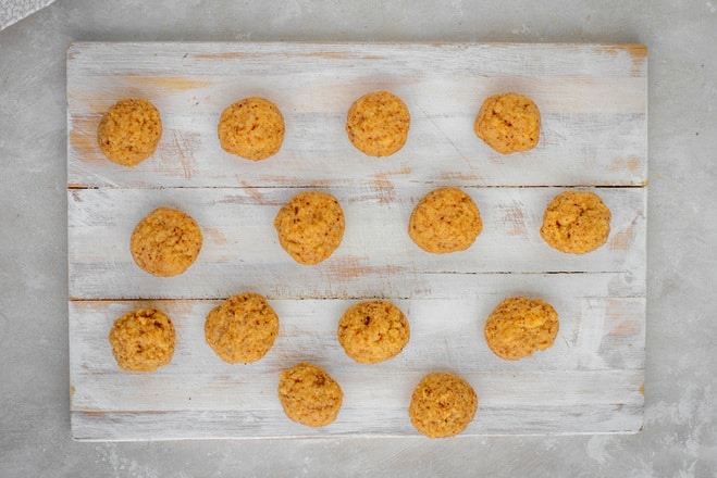 Keto Donuts Perfectly rolled keto donut balls on a white cutting board.