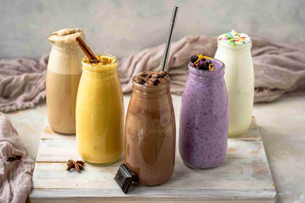 Five colorful jars of keto shakes lined up in a V formation
