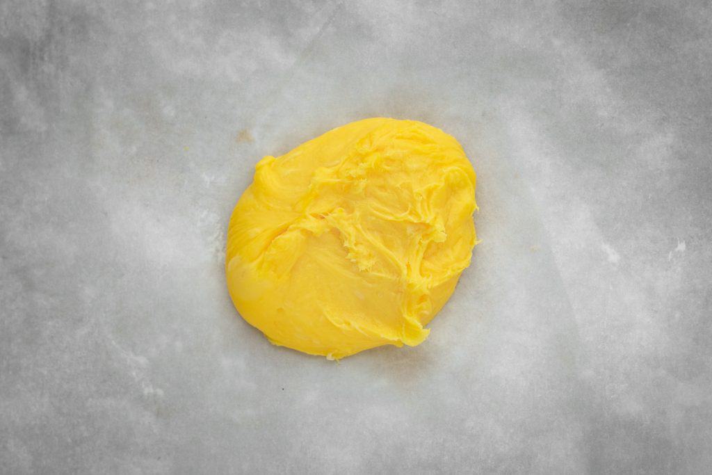 Completed pasta dough placed on a piece of parchment paper to be rolled