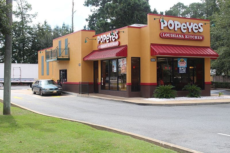 yellow popeyes building with red awnings