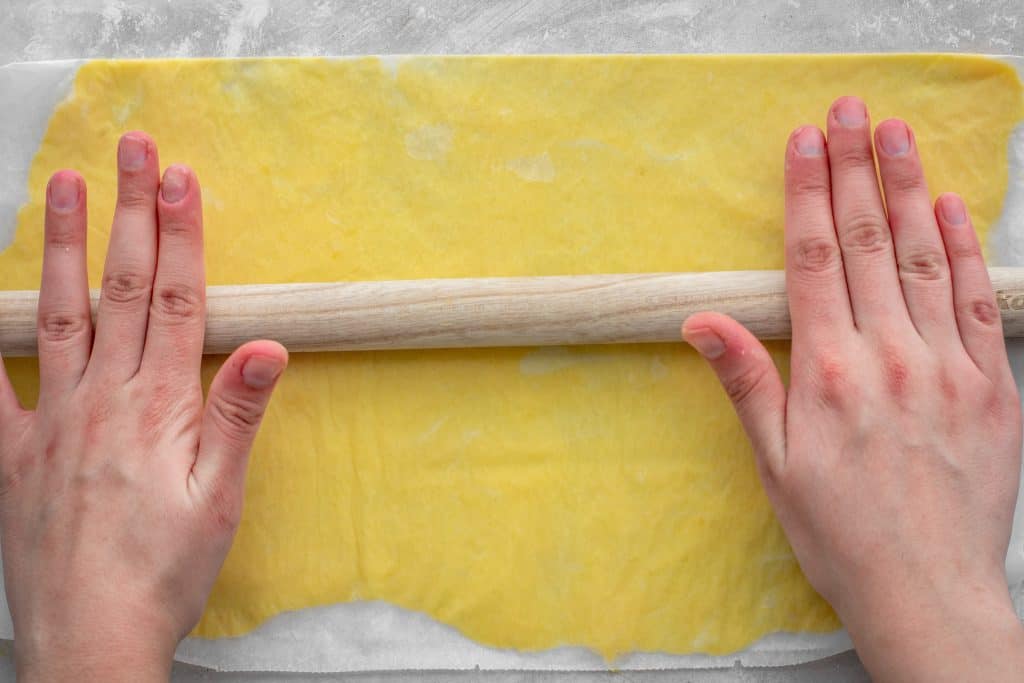 A wooden dowel is used to roll out the keto pasta dough
