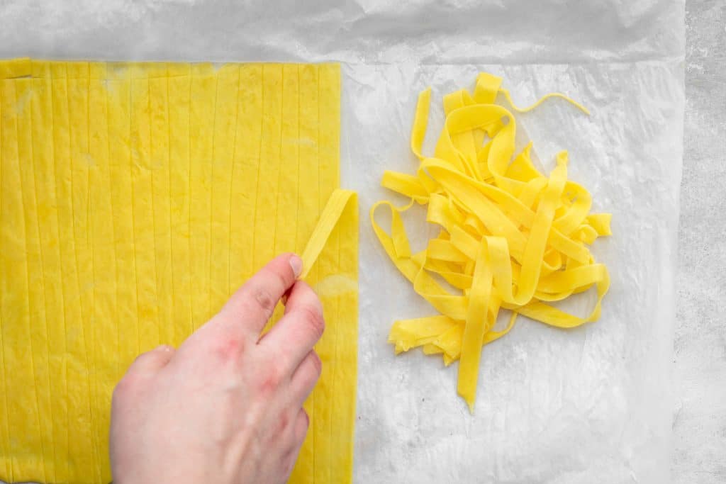 carefully pulling apart the cut pasta to go inside the fridge