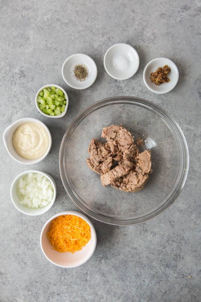 All the ingredients to make tuna casserole in glass and ceramic bowls