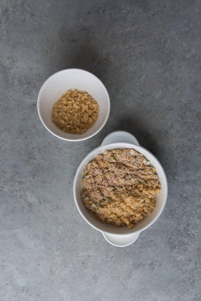 Keto Tuna Casserole Tuna Casserole being topped with the crushed pork rinds