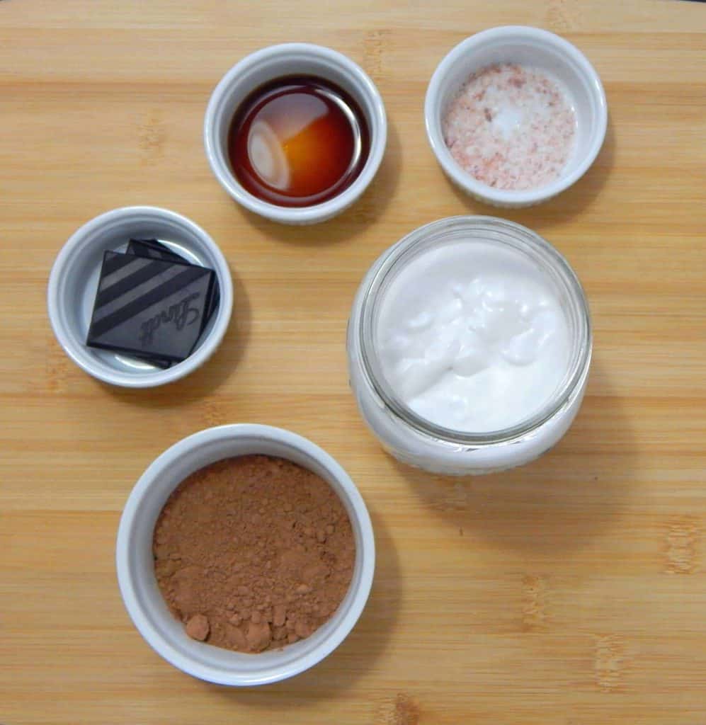 keto hot chocolate Ingredients for hot chocolate in ceramic dishes on a cutting board.