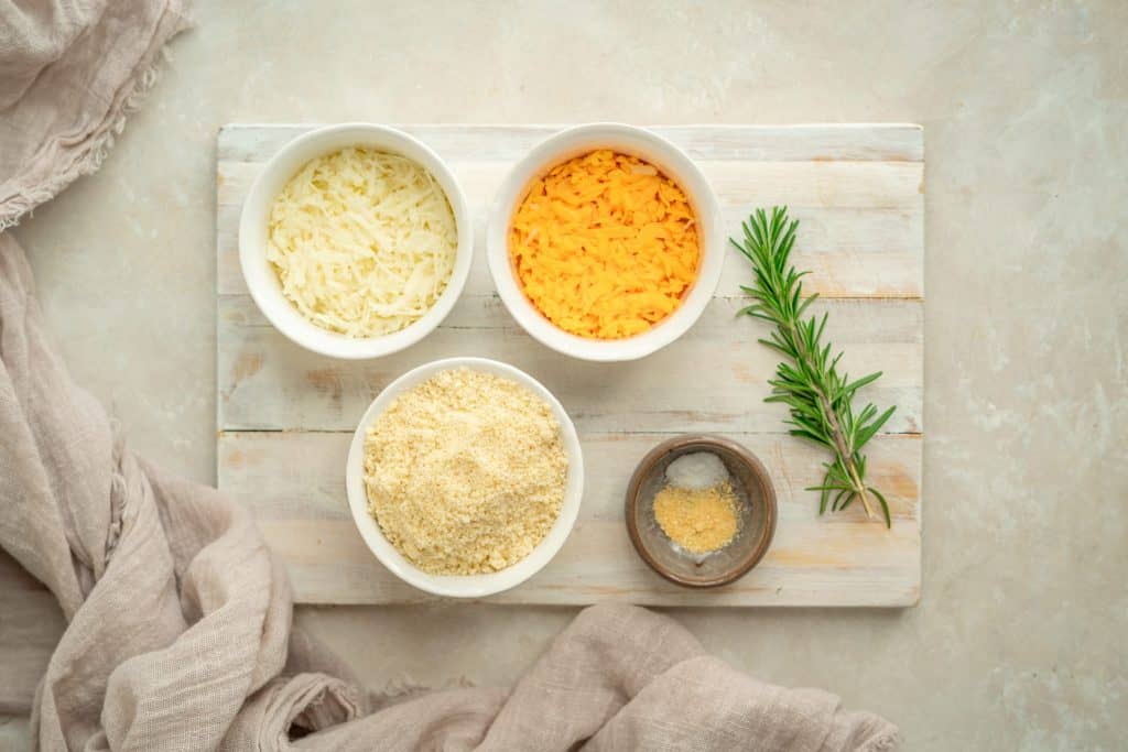 Ingredients for the cheddar crackers on a white wood cutting board