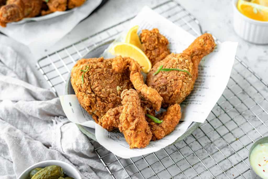 Keto fried chicken in a bowl with lemon wedges