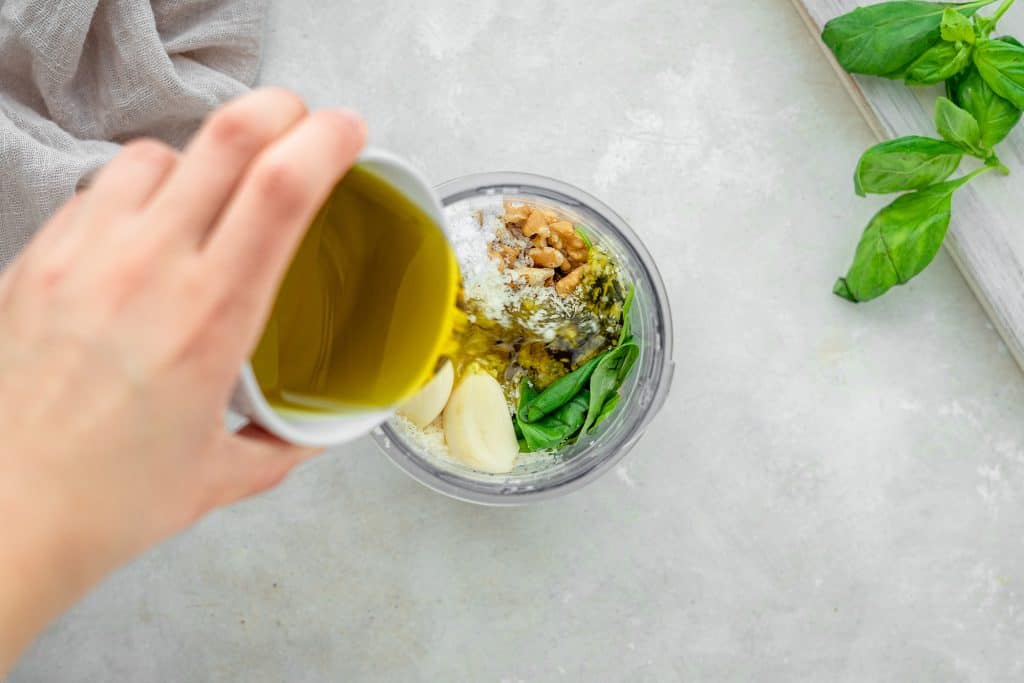 Keto Pesto adding ingredients together with oil