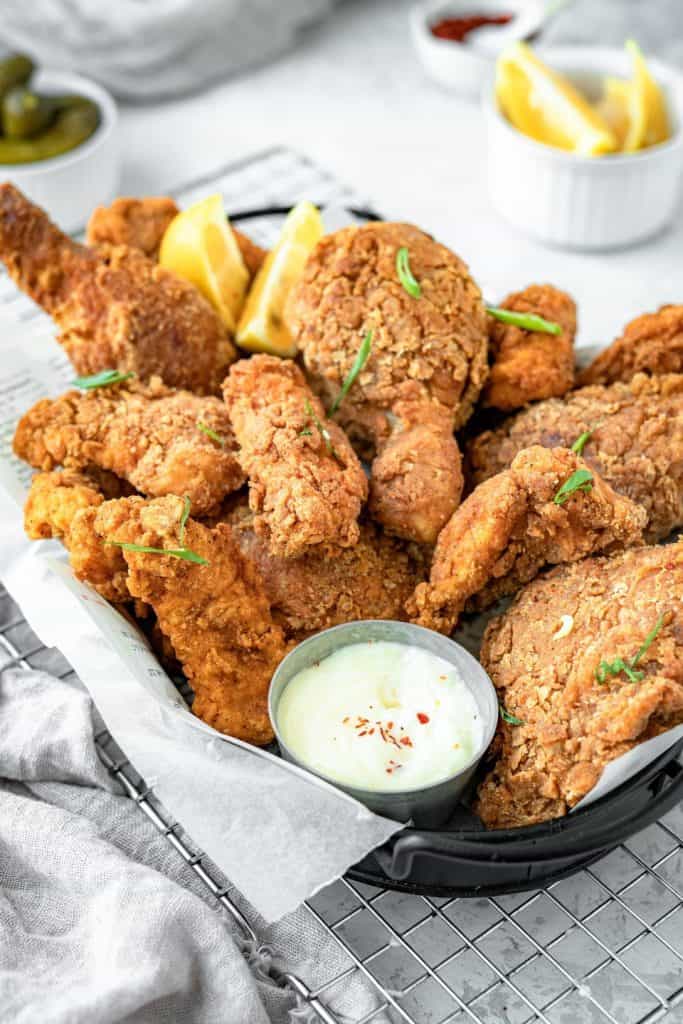 A black basket lined with parchment paper and filled with chicken 