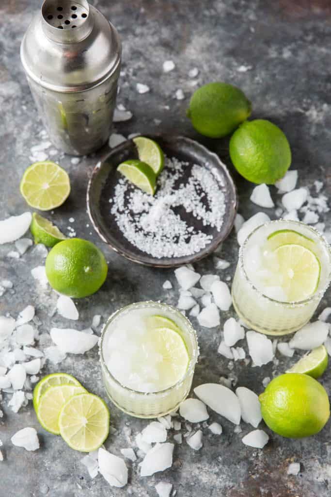 Two Keto Margaritas in glasses topped with lime slices and salt.