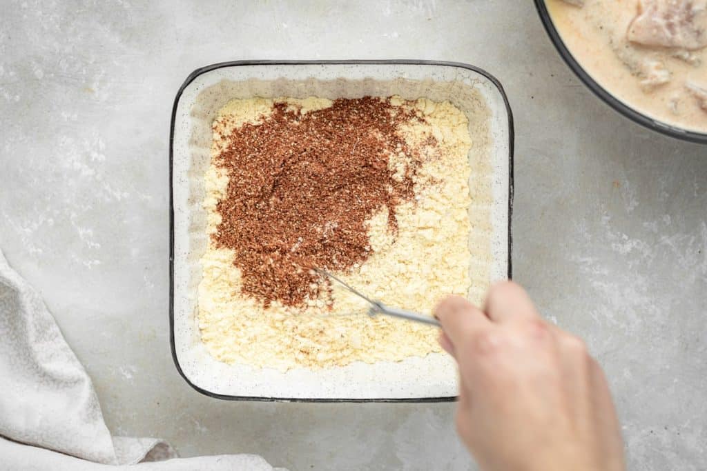 Keto Fried Chicken Mixing together spices in an 8x8 ceramic dish
