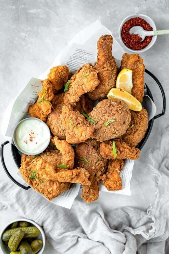 Completed fried chicken with pickles and dipping sauce