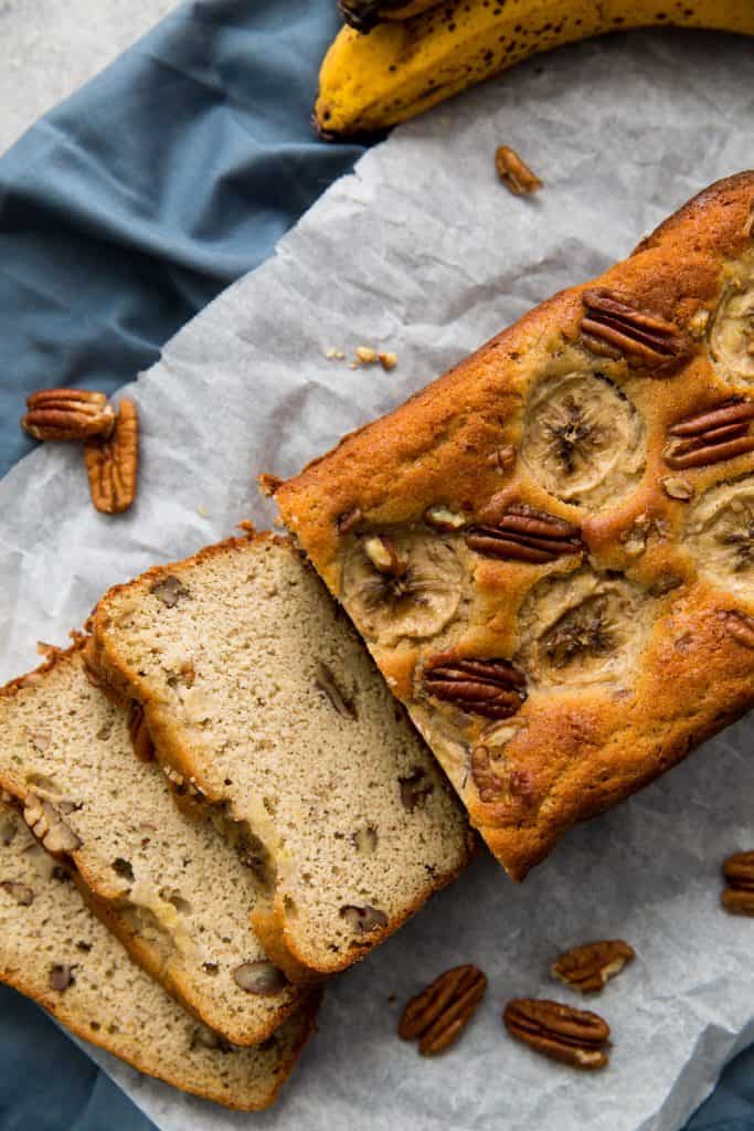 finished banana bread sliced and surrounded by pecans 