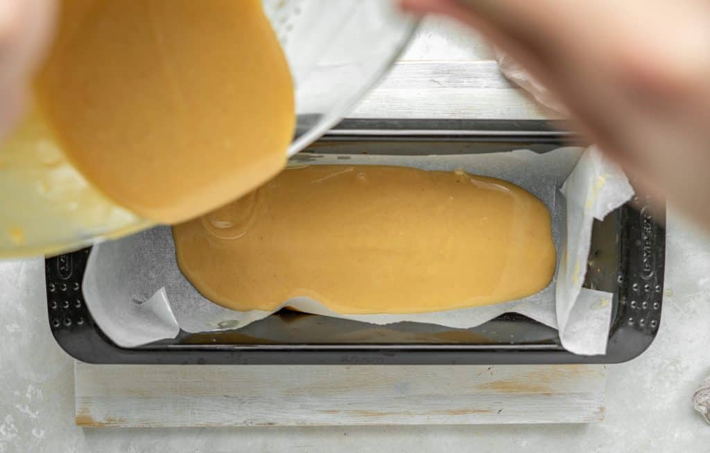 a loaf pan lined with parchment paper is filled with fudge