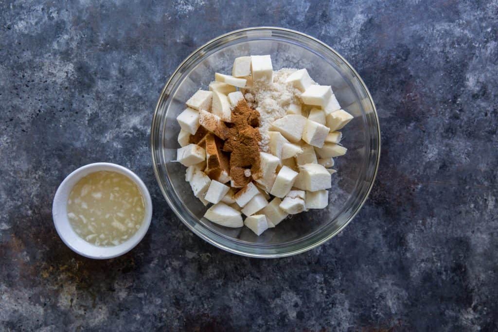 Keto Apple Crisp A glass bowl with chunks of jicima and cinnamon