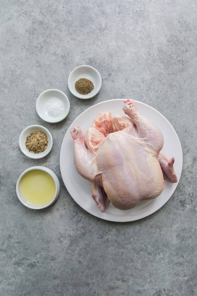 Air Fryer Whole Chicken White plates and bowls with spices and chicken