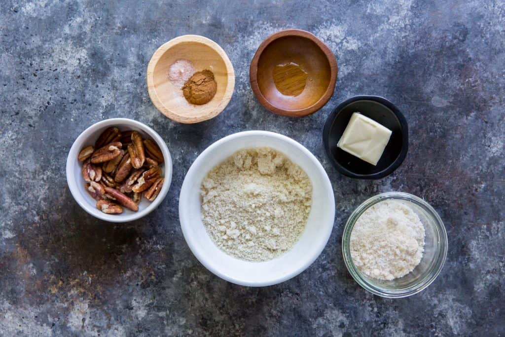 Six bowls with the toppings to make apple crisp