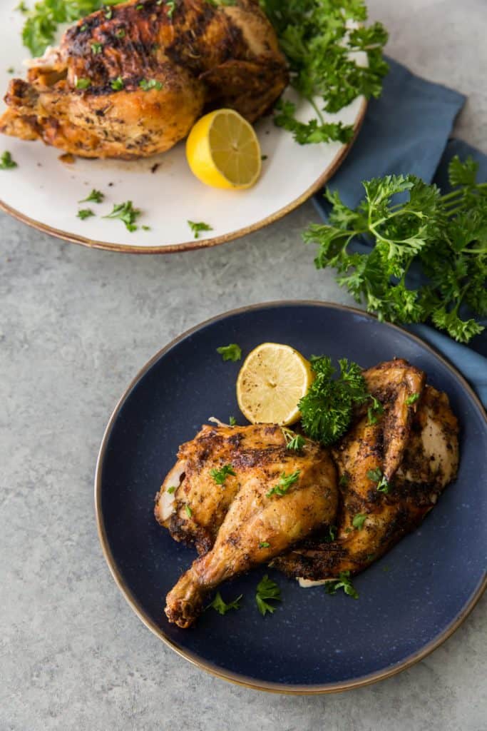 A blue ceramic plate with half a chicken 