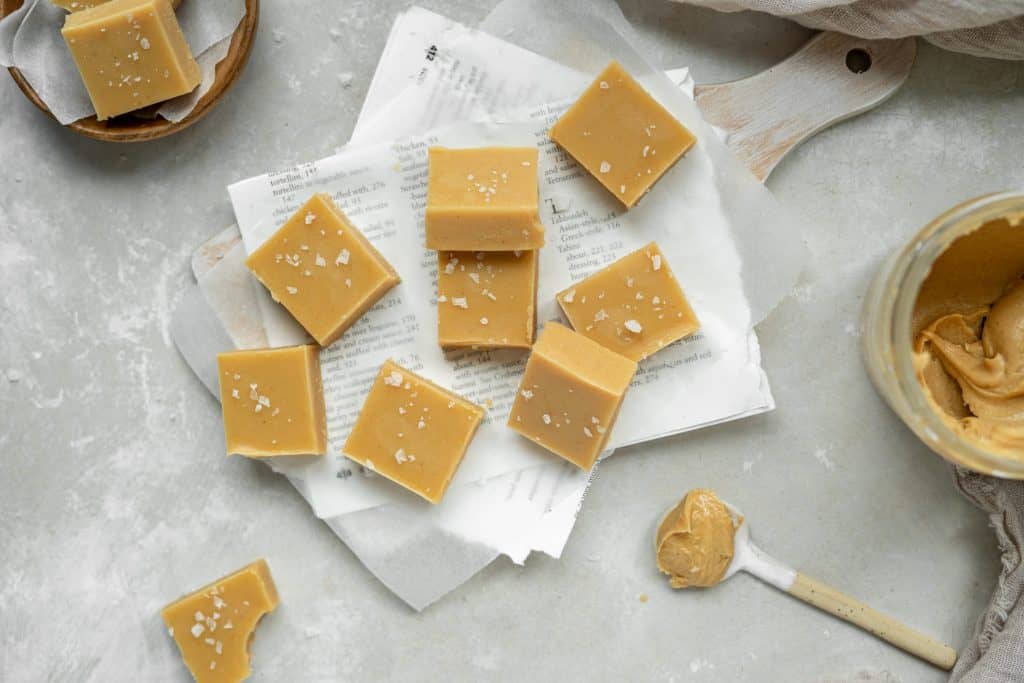 peanut butter fudge surrounded by spoons of peanut butter