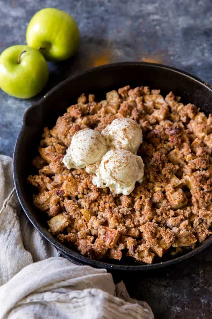 Freshly baked keto apple crisp topped with vanilla ice cream 