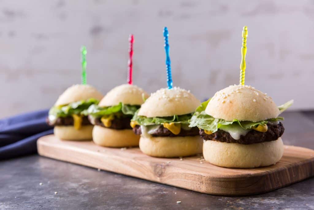 four keto hamburger buns with toothpicks and sesame seeds