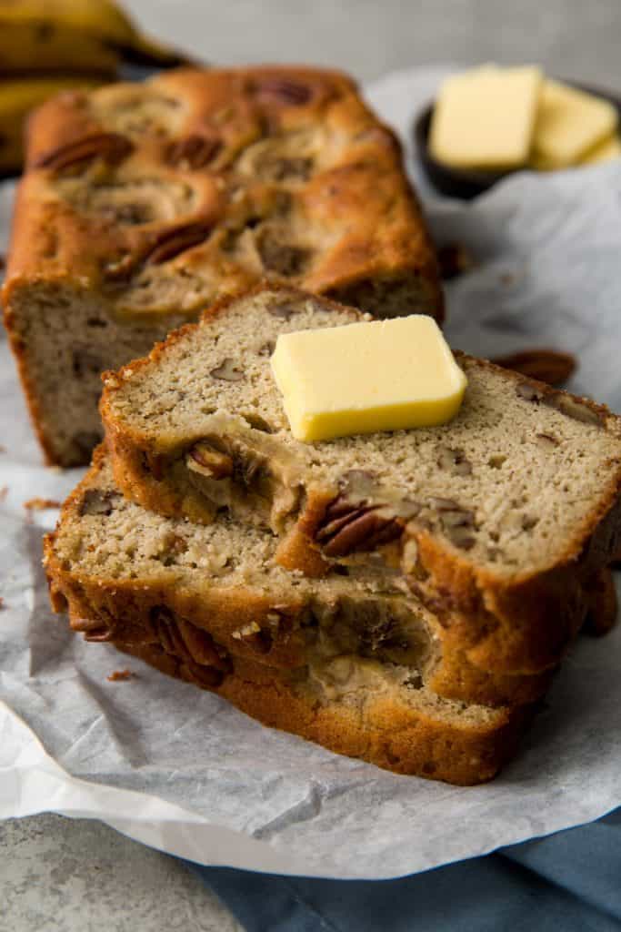 A pat of butter on top of three slices of banana bread