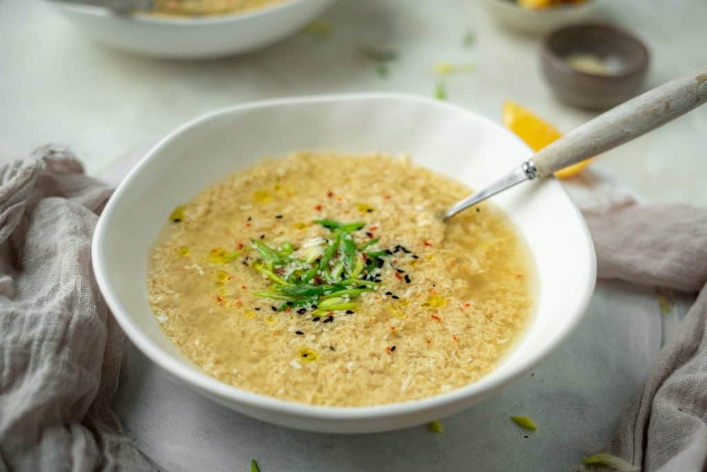 A white bowl full of egg drop soup