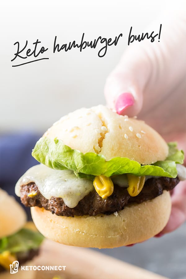 Keto Hamburger Buns hand holding out a hamburger made with keto hamburger buns