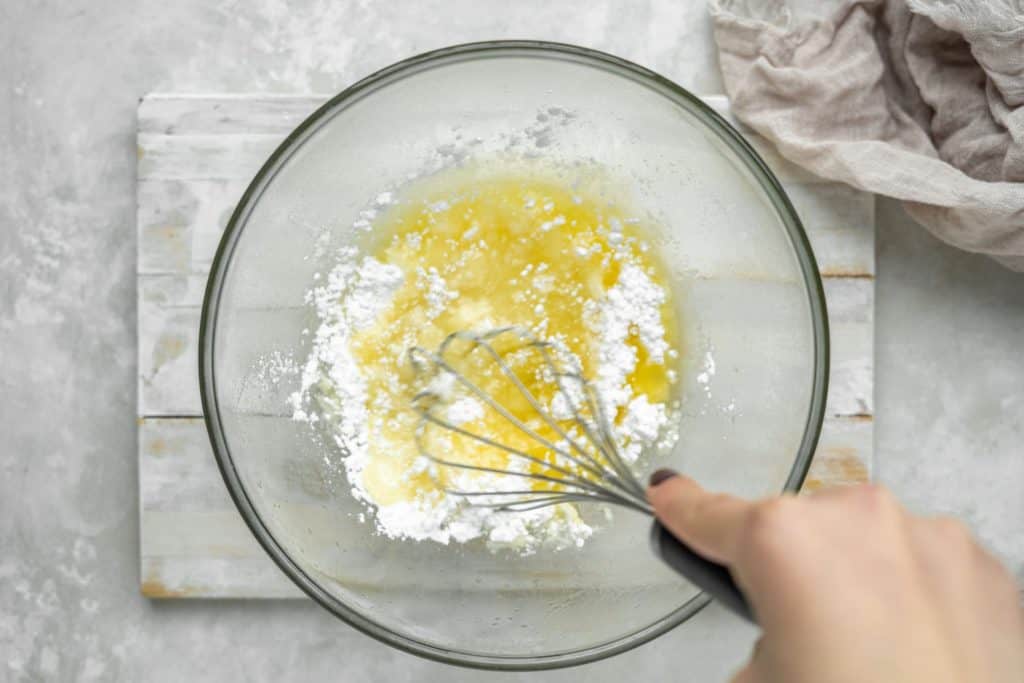 keto peanut butter fudge A hand whisking butter and white powdered sweetener together