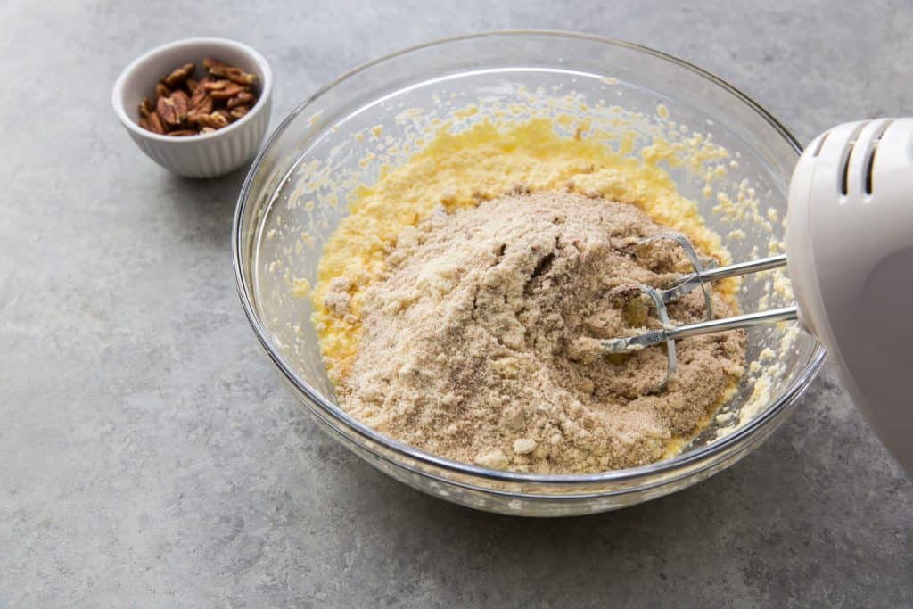 a hand mixer combining the wet and dry ingredients 