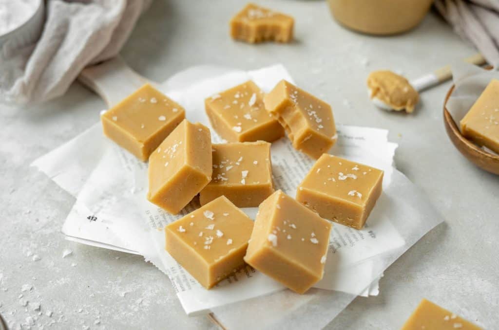 keto peanut butter fudge Square slices of peanut butter fudge set center stage.