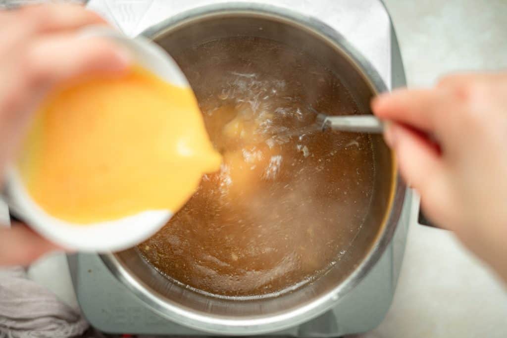 whisked eggs slowly poured into hot chicken broth 