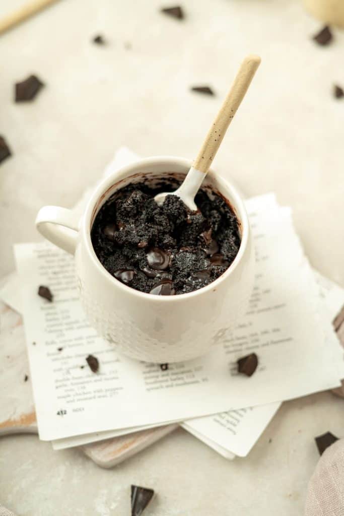 Keto Mug Brownie a mug brownie with lots of chocolate chunks around it.
