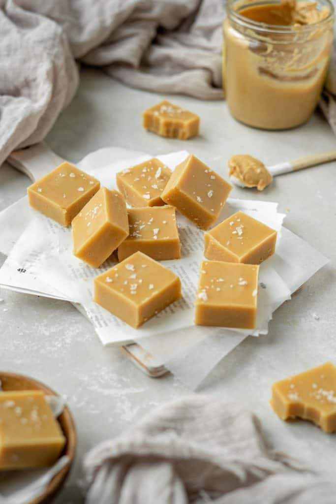 keto peanut butter fudge Fudge on sheets of wax paper with a bite taken out of a piece