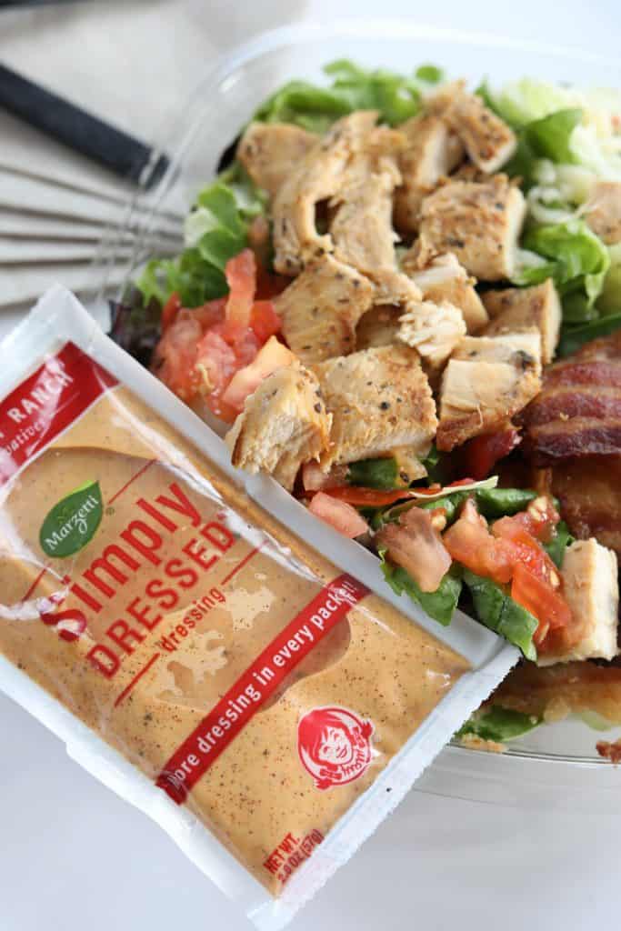 A packet of Wendy's salad dressing on top of a salad