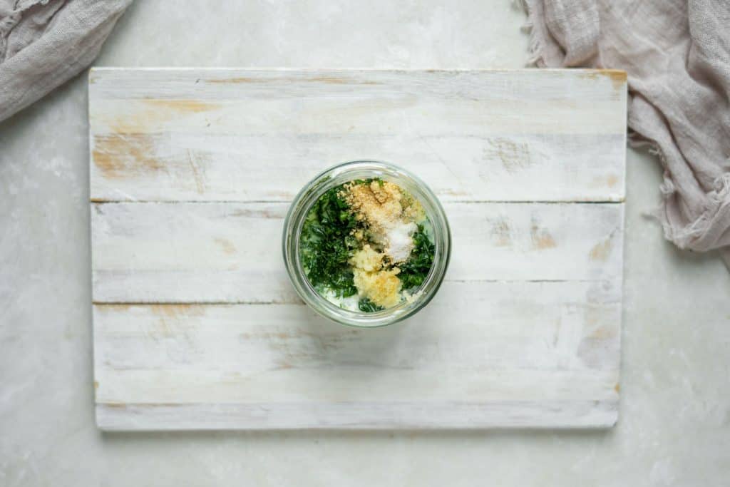 herbs being mixed into keto ranch base