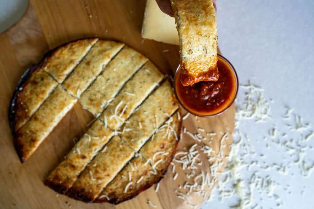 cauliflower cheesesticks on a pizza tray with marinara sauce